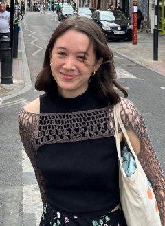 molly chien poses on a street 